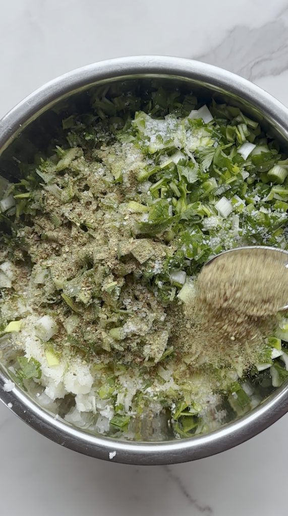 a bowl of mashed potatoes and leeks, cilantro,green onion mix with salt with other seasonings